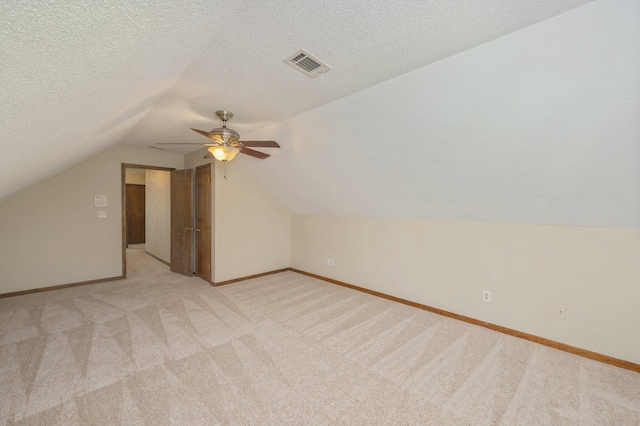 829 S Turnberry Cv, Niceville, FL 32578 - bonus room with light colored carpet, lofted ceiling, ceiling fan, baseboards, and a textured ceiling