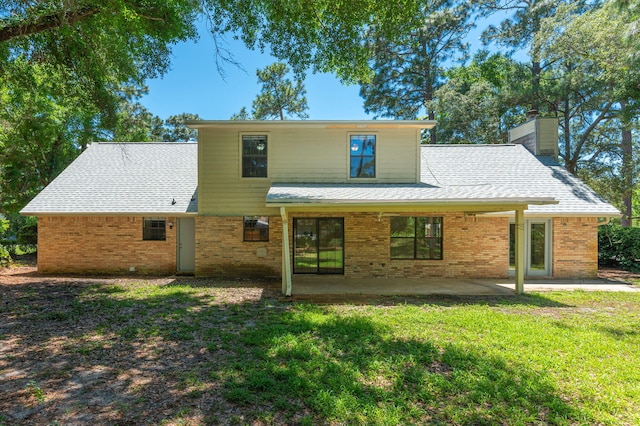 829 S Turnberry Cv, Niceville, FL 32578 - rear view of property with a chimney, brick siding, a lawn, and roof with shingles