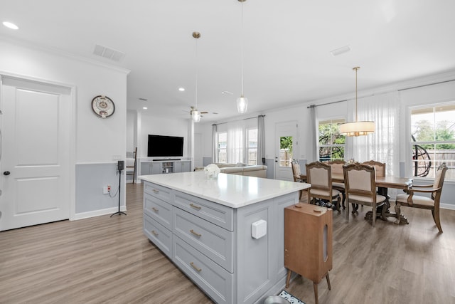 1233 Elderflower Dr, Niceville, FL 32578 - kitchen featuring ornamental molding, light wood-style flooring, a kitchen island, healthy amount of natural light, and open floor plan