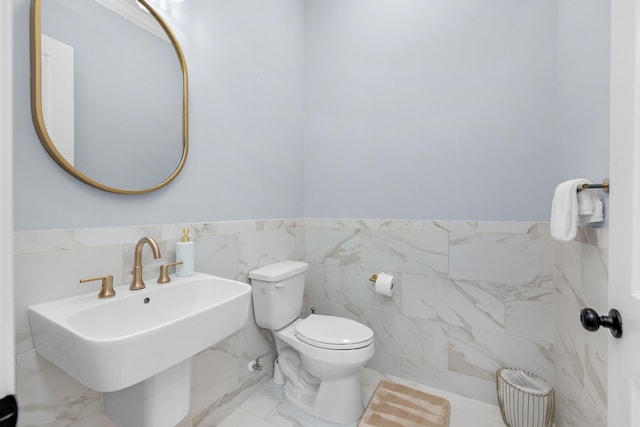 1233 Elderflower Dr, Niceville, FL 32578 - half bathroom with tile walls, toilet, a sink, and a wainscoted wall