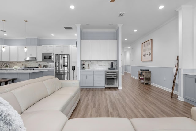 1233 Elderflower Dr, Niceville, FL 32578 - living area featuring beverage cooler, ornamental molding, recessed lighting, baseboards, and light wood-type flooring