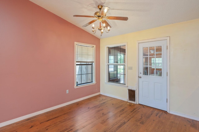 entryway with wood finished floors, baseboards, a ceiling fan, and lofted ceiling