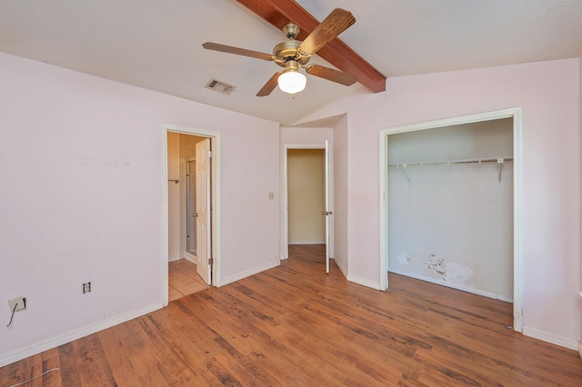 unfurnished bedroom featuring wood finished floors, a closet, and baseboards