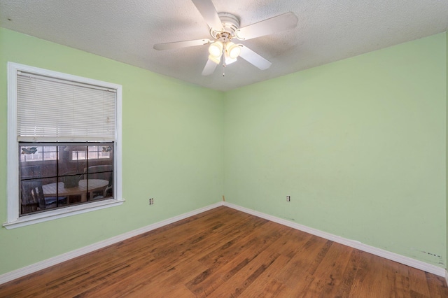 empty room featuring wood finished floors, baseboards, ceiling fan, and a textured ceiling