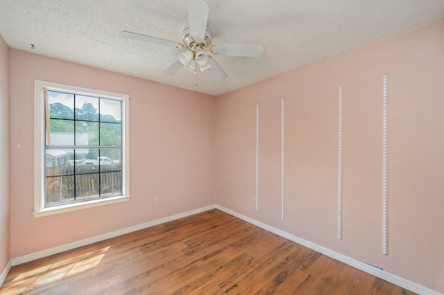 unfurnished room featuring baseboards, wood finished floors, a textured ceiling, and a ceiling fan