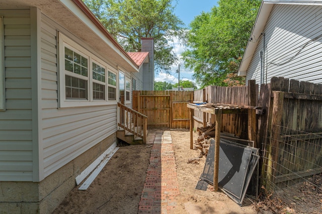 view of side of home featuring fence and a gate