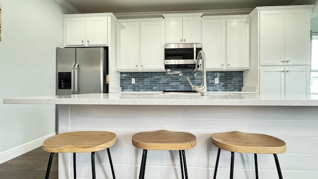 9 Inlet Heights Ln, Inlet Beach, FL 32461 - kitchen with appliances with stainless steel finishes, baseboards, white cabinets, decorative backsplash, and ornamental molding