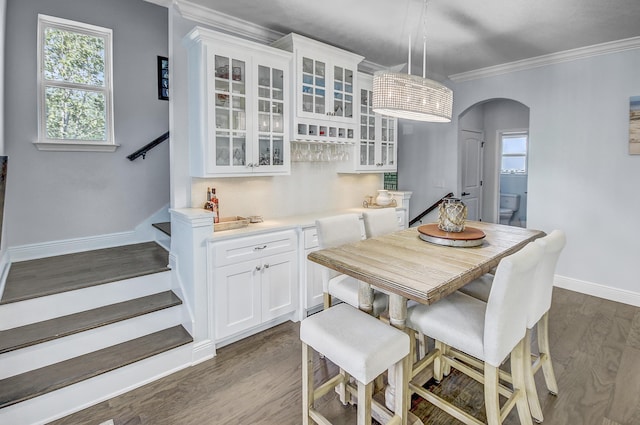 9 Inlet Heights Ln, Inlet Beach, FL 32461 - dining area with arched walkways, a dry bar, stairs, crown molding, and dark wood finished floors