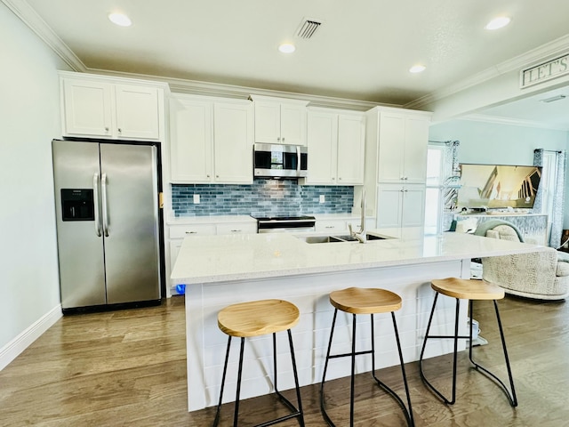 9 Inlet Heights Ln, Inlet Beach, FL 32461 - kitchen with stainless steel appliances, a sink, white cabinetry, tasteful backsplash, and a breakfast bar