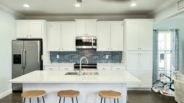 9 Inlet Heights Ln, Inlet Beach, FL 32461 - kitchen with stainless steel appliances, a sink, a breakfast bar area, white cabinetry, and crown molding