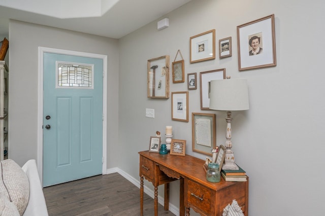 foyer entrance with dark wood-style flooring and baseboards