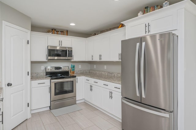 kitchen with stainless steel appliances, white cabinets, recessed lighting, and light stone countertops