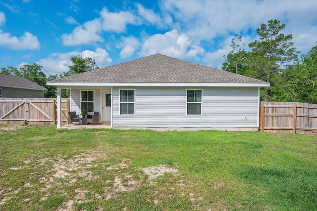 rear view of house featuring roof with shingles and a patio area