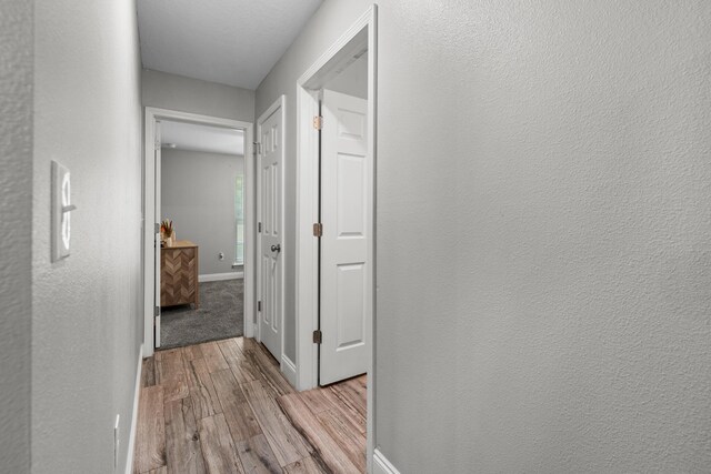 hall with wood finished floors and baseboards