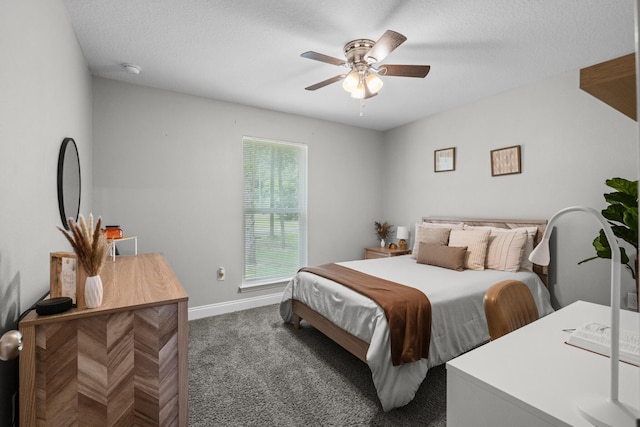 bedroom featuring dark colored carpet, baseboards, a ceiling fan, and a textured ceiling