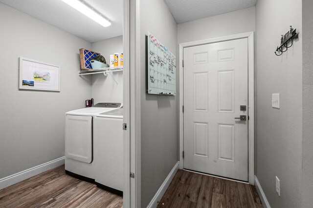 laundry room with washing machine and clothes dryer, dark wood-style floors, and baseboards