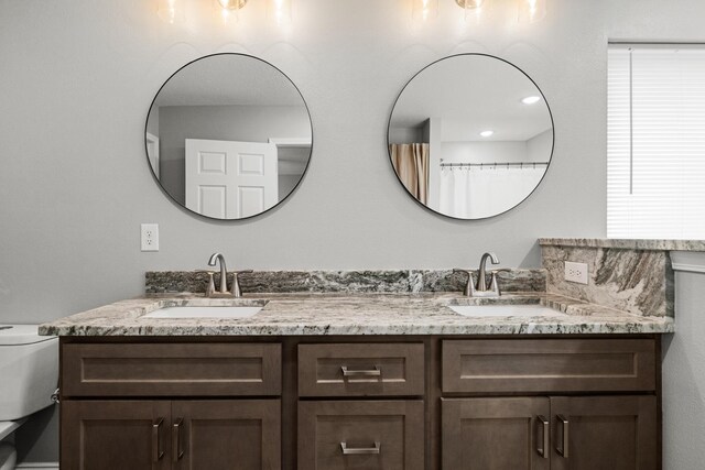 bathroom featuring double vanity and toilet