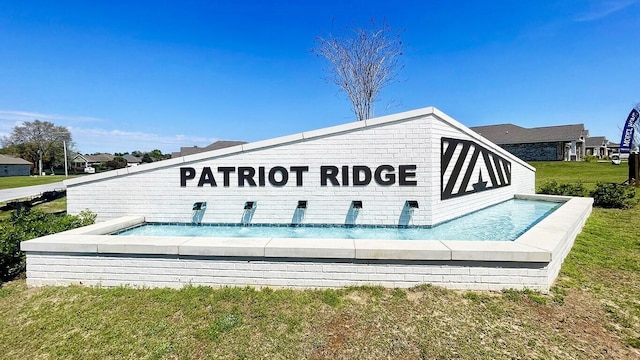 community / neighborhood sign with a lawn