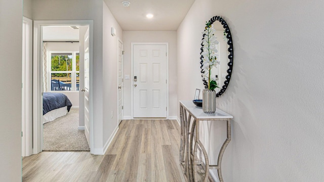 hall with light wood-style floors and baseboards