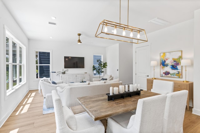 dining space featuring light wood-style floors, ceiling fan, and baseboards