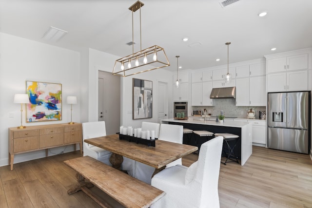 dining area featuring light wood finished floors and recessed lighting