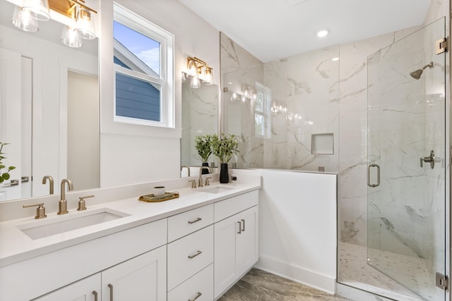 full bath featuring a marble finish shower, marble look tile flooring, double vanity, and recessed lighting