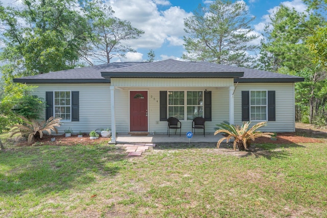 view of front of home with covered porch, a front lawn, and a shingled roof