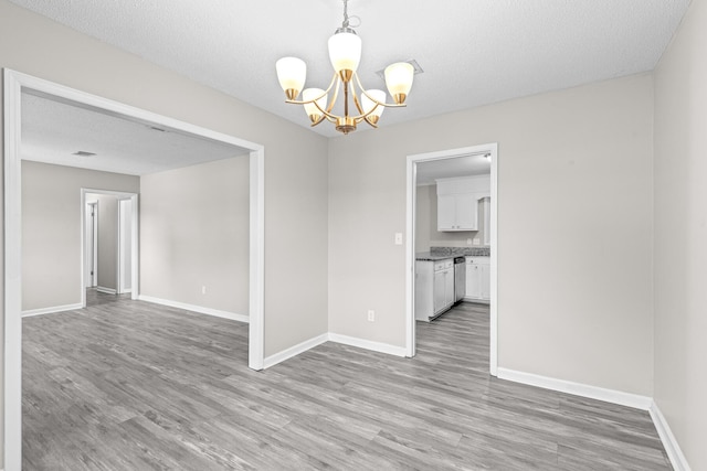 4360 Beau Terra Ln, Pensacola, FL 32514 - unfurnished dining area with a chandelier, wood finished floors, baseboards, and a textured ceiling