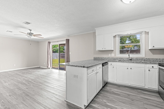 4360 Beau Terra Ln, Pensacola, FL 32514 - kitchen with stainless steel dishwasher, a textured ceiling, a peninsula, a ceiling fan, and crown molding