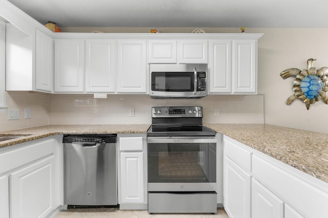 11 Beachside Dr Unit 613, Santa Rosa Beach, FL 32459 - kitchen with stainless steel appliances, white cabinets, and decorative backsplash