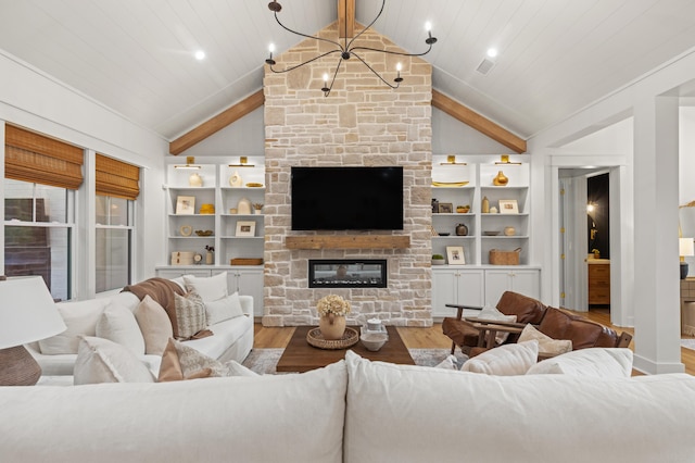 living area featuring wood finished floors, vaulted ceiling, a chandelier, and a fireplace