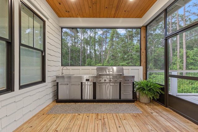 unfurnished sunroom with a sink and an outdoor kitchen