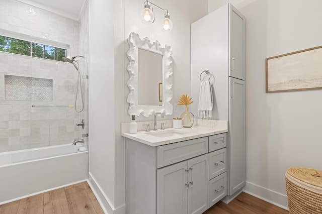 full bathroom featuring wood finished floors, baseboards, shower / bathtub combination, and vanity