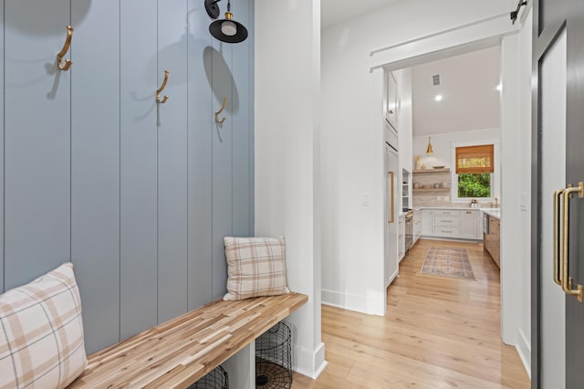 mudroom featuring light wood-type flooring and baseboards