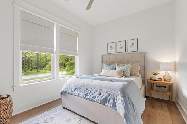 bedroom featuring wood finished floors, baseboards, and a ceiling fan