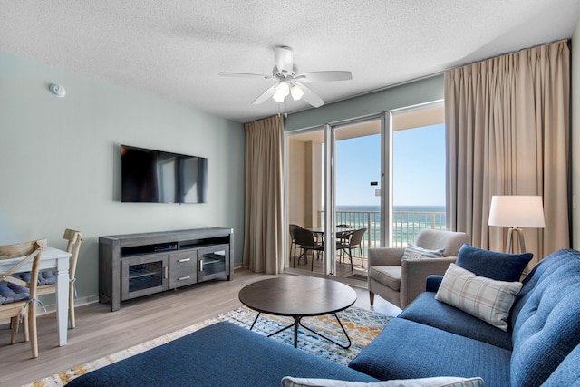 1200 Scenic Gulf Dr Unit B507, Miramar Beach, FL 32550 - living room featuring a ceiling fan, wood finished floors, a textured ceiling, and baseboards