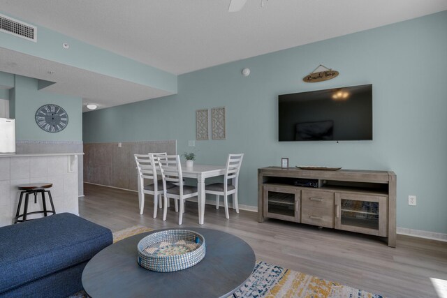 1200 Scenic Gulf Dr Unit B507, Miramar Beach, FL 32550 - living room with wood finished floors, baseboards, wainscoting, and tile walls