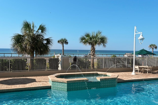 1200 Scenic Gulf Dr Unit B507, Miramar Beach, FL 32550 - view of pool with a pool with connected hot tub, a water view, fence, and a patio