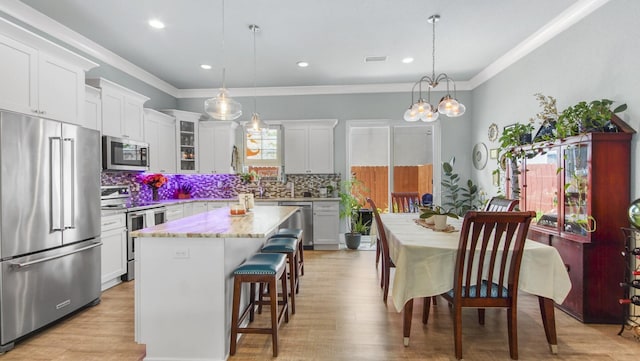 995 Airport Rd Unit 28, Destin, FL 32541 - kitchen with stainless steel appliances, backsplash, a breakfast bar area, a center island, and ornamental molding