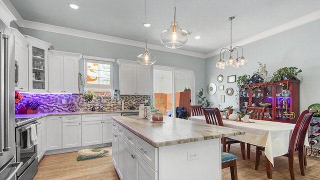 995 Airport Rd Unit 28, Destin, FL 32541 - kitchen with electric stove, light countertops, a kitchen island, a kitchen bar, and decorative backsplash