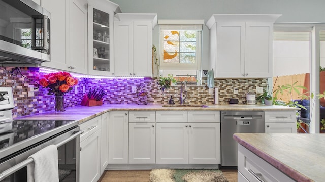 995 Airport Rd Unit 28, Destin, FL 32541 - kitchen featuring stainless steel appliances, a sink, decorative backsplash, and white cabinetry