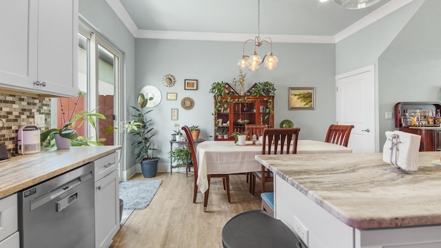 995 Airport Rd Unit 28, Destin, FL 32541 - dining space featuring light wood-type flooring, crown molding, a chandelier, and baseboards