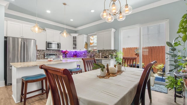 995 Airport Rd Unit 28, Destin, FL 32541 - dining area featuring light wood-style flooring, a chandelier, recessed lighting, and ornamental molding