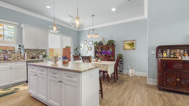 995 Airport Rd Unit 28, Destin, FL 32541 - kitchen with a sink, light wood-type flooring, light countertops, a chandelier, and a center island