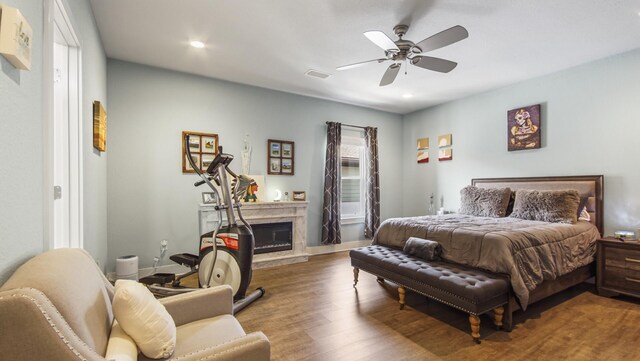 995 Airport Rd Unit 28, Destin, FL 32541 - bedroom featuring a glass covered fireplace, wood finished floors, recessed lighting, a ceiling fan, and baseboards