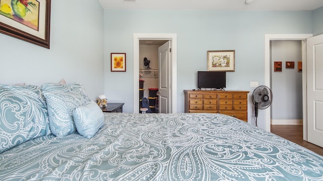 995 Airport Rd Unit 28, Destin, FL 32541 - bedroom with wood finished floors, a walk in closet, a closet, and baseboards