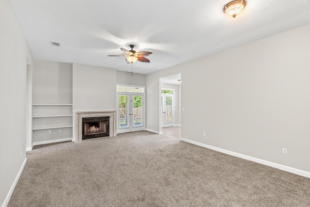 123 Bonaire Blvd, Miramar Beach, FL 32550 - unfurnished living room with a ceiling fan, a textured ceiling, carpet floors, baseboards, and a fireplace