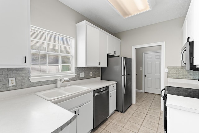 123 Bonaire Blvd, Miramar Beach, FL 32550 - kitchen featuring stainless steel appliances, white cabinets, light tile patterned flooring, a sink, and backsplash