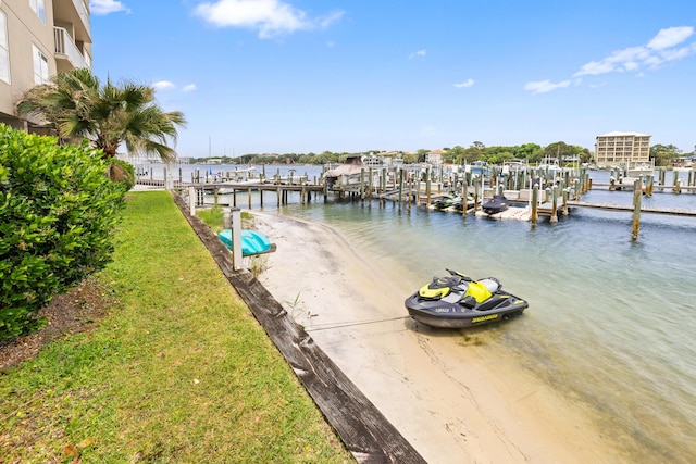 dock area with a water view and a lawn