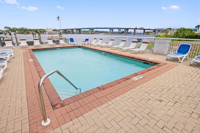 community pool featuring fence and a patio area